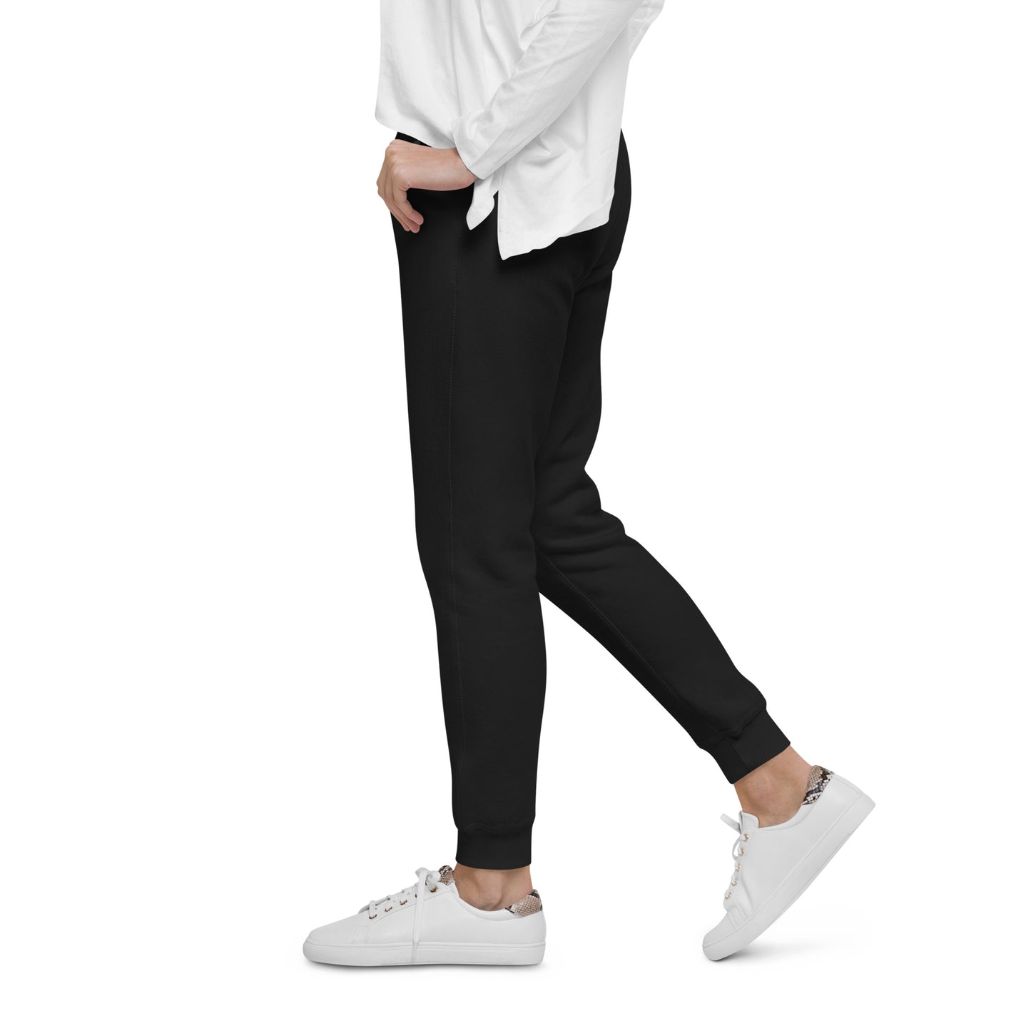 Person wearing black jogger pants and white sneakers on a white background