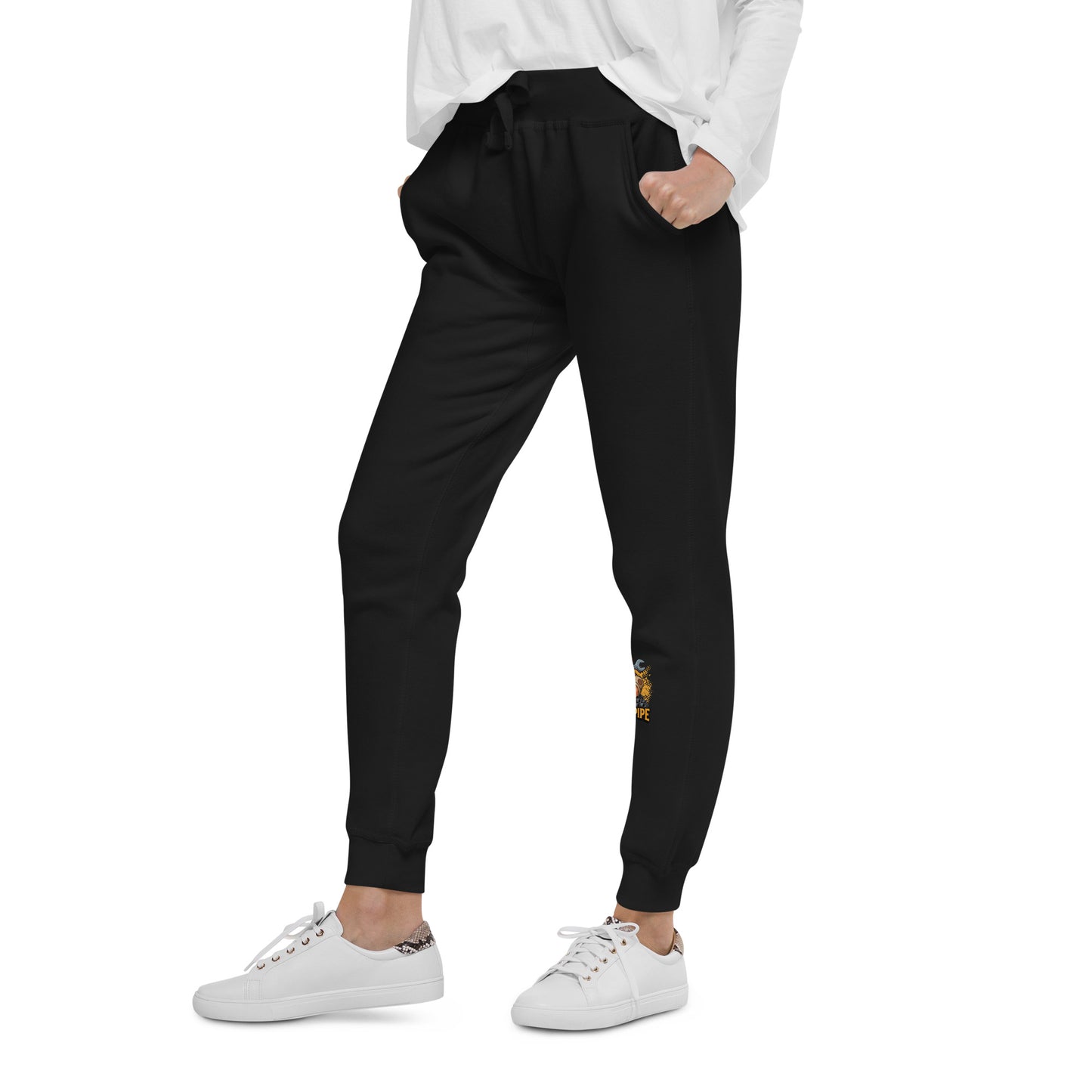 Person wearing black jogger pants with a small yellow design on a white background
